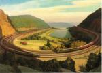<i>The Horseshoe Curve</i>, by Grif Teller Oil on canvas of the entire expanse of the curve, providing a bird's eye view. Image includes three trains traveling around the four-track curve.  It is summer and the mountains are lush and green. 