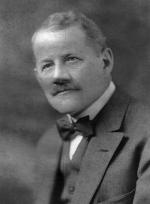 Head and shoulders photograph of Mishler wearing a vest, suit jacket, and a bow-tie.