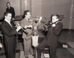 Noted orchestra leaders Buddy Rogers; Jan Savitt of KYW; and Tommy Dorsey (L-R) are pictured as putting on an impromtu "swing" show for studio technicians and musicians.
