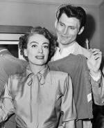 Jack Palance helping Joan Crawford with her Coat.