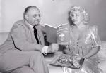 Mae West, is shown in her sumptuous Hollywood apartment as she recently discussed moral Rearmament with Dr. Frank Buchman, leader of that movement.
