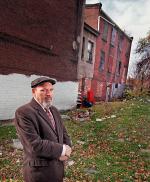 Playwright August Wilson standing in front of his boyhood home (far right) on Bedford Street in Pittsburgh.