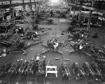 Image of an interior factory with guns and employees